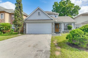 A residential house with a garage, a front yard with a lawn, and a driveway. - 10 Mi to Airport & Vintage Park! Quaint Apartment (Houston)