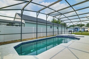 A swimming pool with a clear blue water feature, surrounded by a white fence and a metal structure overhead. - Swim, Golf & Park-hop! Family Home in Davenport (Davenport)