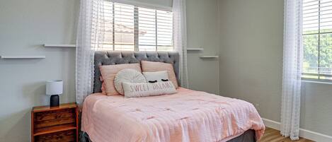 A bedroom with a bed, nightstand, and a ceiling fan.