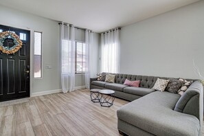 A living room with a sectional sofa, a round ottoman, a small coffee table, and a black door with a wreath. - Outdoor Oasis w/ Pool! Glendale Group Escape (Glendale)