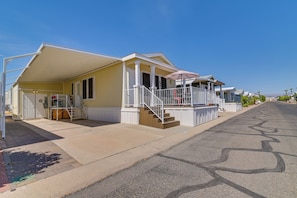 A residential building with a covered porch, a staircase, and a driveway. - Complimentary Golf Cart! Viewpoint Resort Home (Mesa)