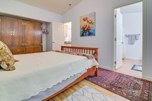 Una camera da letto con un letto, un'armadio in legno e un quadro appeso al muro.