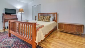 A bedroom with a wooden bed, a television, a lamp, and a small cabinet. - Complimentary Golf Cart! Viewpoint Resort Home (Mesa)