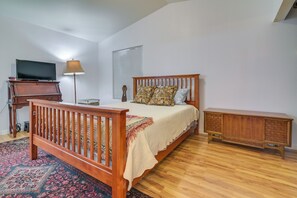 A bedroom with a wooden bed, a television, a lamp, and a small cabinet. - Complimentary Golf Cart! Viewpoint Resort Home (Mesa)