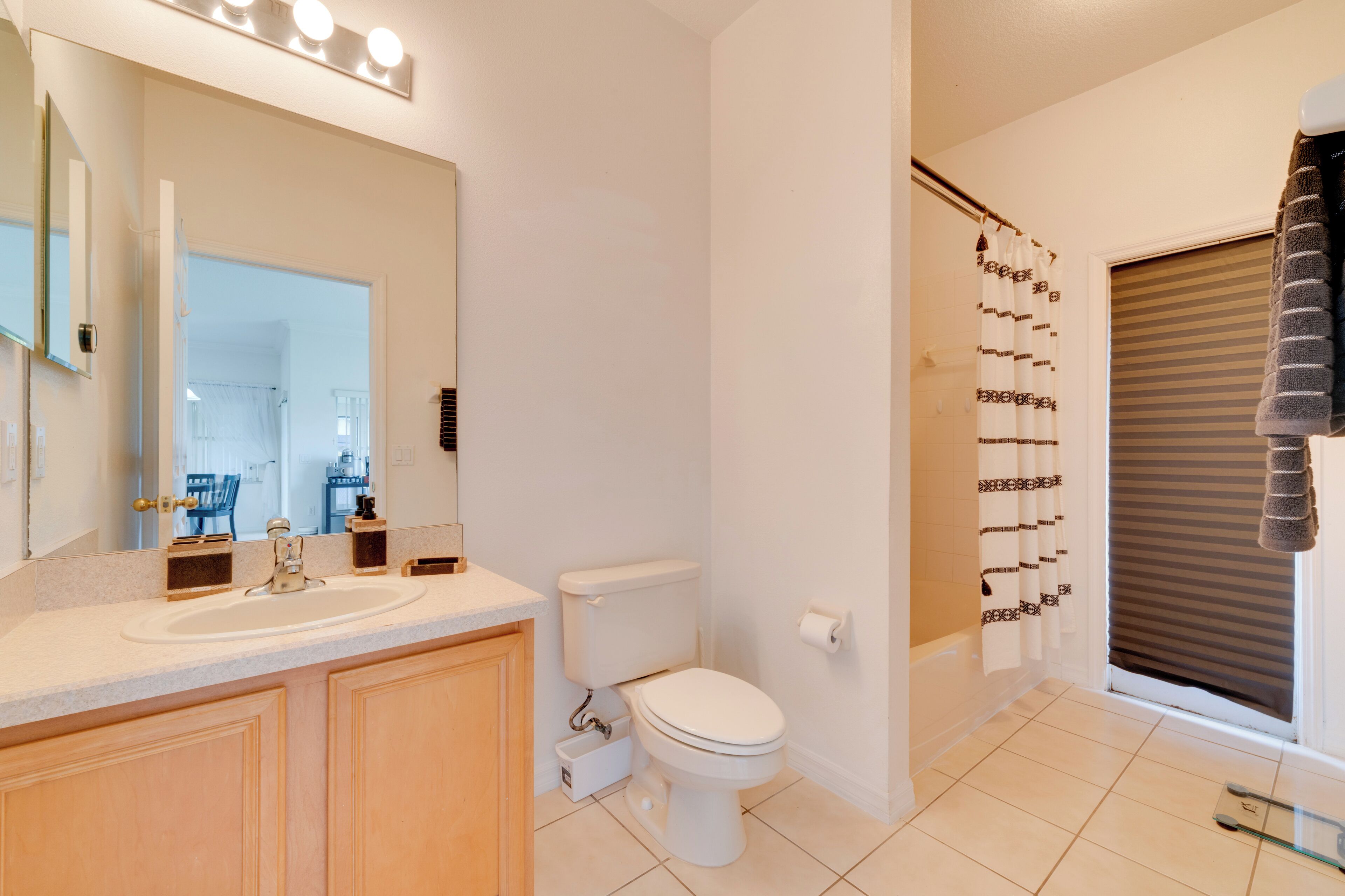 A bathroom with a sink, toilet, and a shower curtain with a geometric pattern.