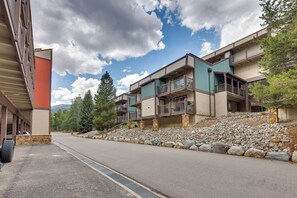 A multi-story hotel with balconies, a stone retaining wall, and a clear sky. - Hike, Bike & Ski! Cozy Condo 8 Mi to Lake Dillon (Breckenridge)