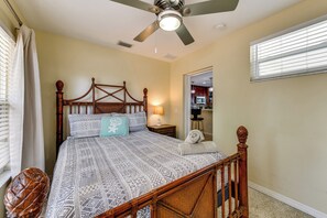 A bedroom with a wooden four-poster bed, a ceiling fan, and a view of the kitchen through an open doorway. - Walk to Park & Pool: Sarasota Family Home w/ Yard (Sarasota)