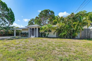 A single-story house with a covered porch, surrounded by a grassy yard and various trees. - Walk to Park & Pool: Sarasota Family Home w/ Yard (Sarasota)