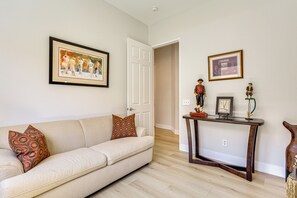 A living room with a sofa, a coffee table, and a door leading to another room. - Indian Palms Retreat Across From Empire Polo Club (Indio)
