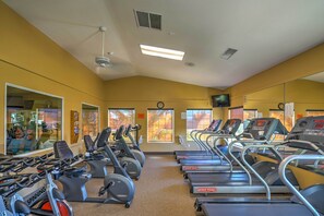 A gym with multiple treadmills and stationary bikes, large windows, and a mirror reflecting the equipment. - Indian Palms Retreat Across From Empire Polo Club (Indio)