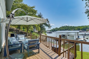 A deck with outdoor furniture and a view of a lake with boats. - Boat Dock & Slip! Group-ready Lake Ozark Home (Lake Ozark)