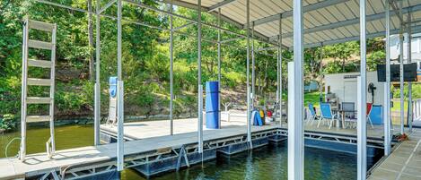 Un muelle techado con una escalera, asientos y una pequeña piscina.