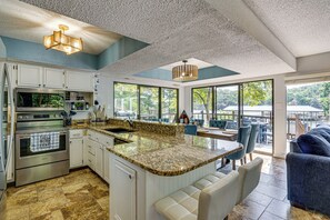 A modern kitchen with granite countertops, stainless steel appliances, and a large island.