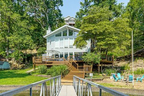 A two-story house with a deck, a staircase, and outdoor seating. - Boat Dock & Slip! Group-ready Lake Ozark Home (Lake Ozark)