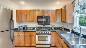 Una cocina moderna con armarios de madera, electrodomésticos de acero inoxidable y un ventanal que proporciona luz natural.