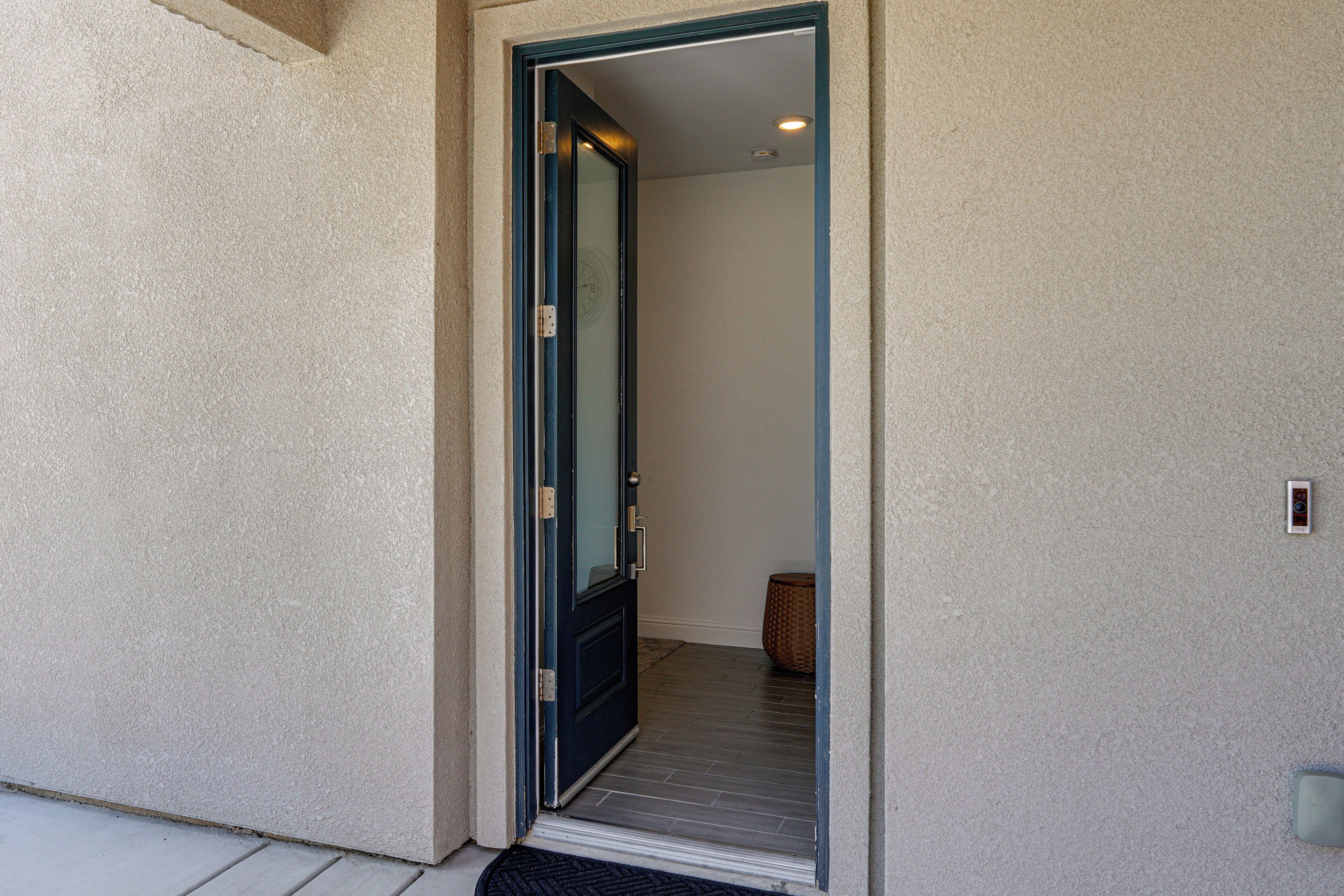 A doorway leading to a room with a visible door handle and a small rug on the floor.