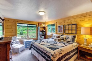 A wooden cabin bedroom with a large bed, a desk, and a chair. - Durango Mountain Escape: Hike, Bike & Explore! (Durango)