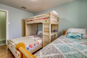 A bunk bed with a lower bunk and a single bed, both with floral bedding. - Luxe Hill Country Home w/ Resort-style Pool! (Buda)