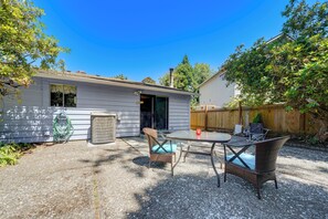 A residential property with a patio area featuring a table and chairs, a small shed, and a wooden fence. - Private Yard & Patio! Pet-friendly Lynnwood Home (Lynnwood)