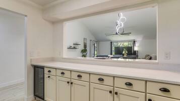 A kitchen with a large mirror, cabinets, and a countertop.