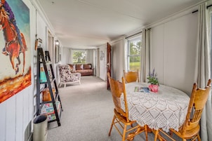A dining area with a round table, chairs, and a view of the outdoors.