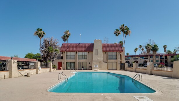 A swimming pool with a red-roofed building in the background, surrounded by palm trees. - Walkable & Renovated Gem! Only 8 Mi to Dtwn Tucson (Tucson)