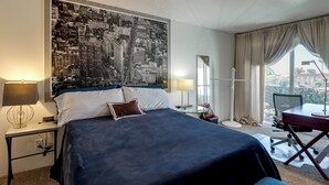 A hotel room with a large bed, two bedside tables with lamps, a desk with a chair, and a large window with curtains. - Walkable & Renovated Gem! Only 8 Mi to Dtwn Tucson (Tucson)