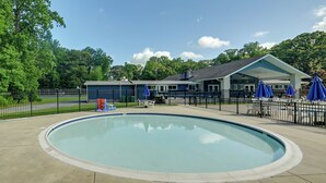 A swimming pool with a covered seating area and umbrellas, surrounded by a fence and trees. - Lewes Family Escape w/ Angola by the Bay Amenities (Lewes)
