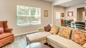 A living room with a sectional sofa, a coffee table, and a window with blinds.