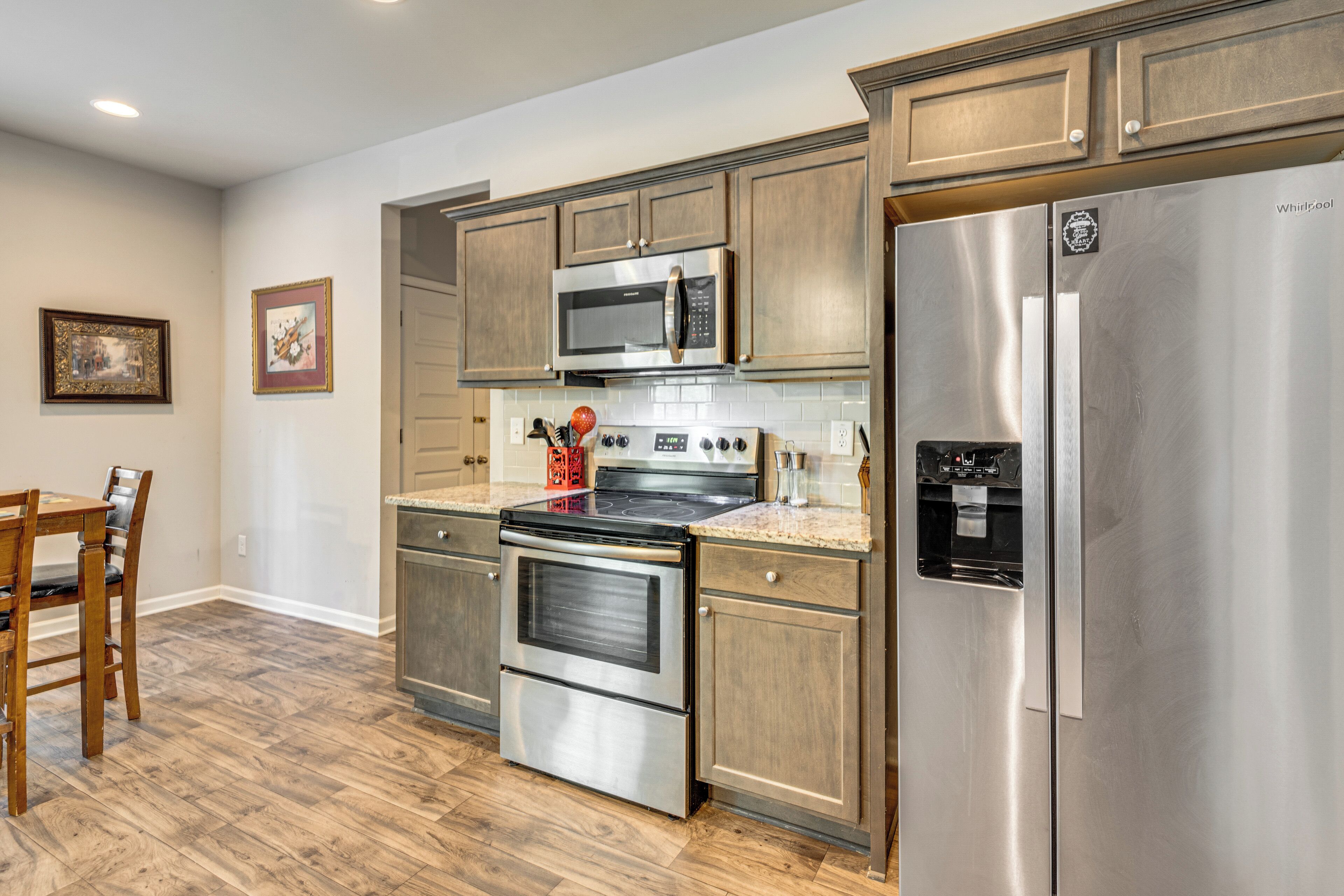 A kitchen with stainless steel appliances, wooden cabinets, and a water dispenser.