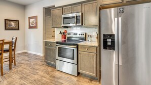 A kitchen with stainless steel appliances, wooden cabinets, and a water dispenser.