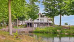 A two-story house with a balcony, surrounded by trees and a pond. - Unplug & Unwind! Romulus Family Gem w/ Swim Pond (Romulus)