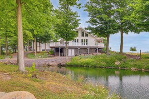 A two-story house with a balcony, surrounded by trees and a pond. - Unplug & Unwind! Romulus Family Gem w/ Swim Pond (Romulus)