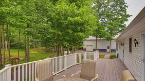 A covered outdoor deck with a round table and chairs, surrounded by a white railing, overlooking a grassy area with trees. - Unplug & Unwind! Romulus Family Gem w/ Swim Pond (Romulus)