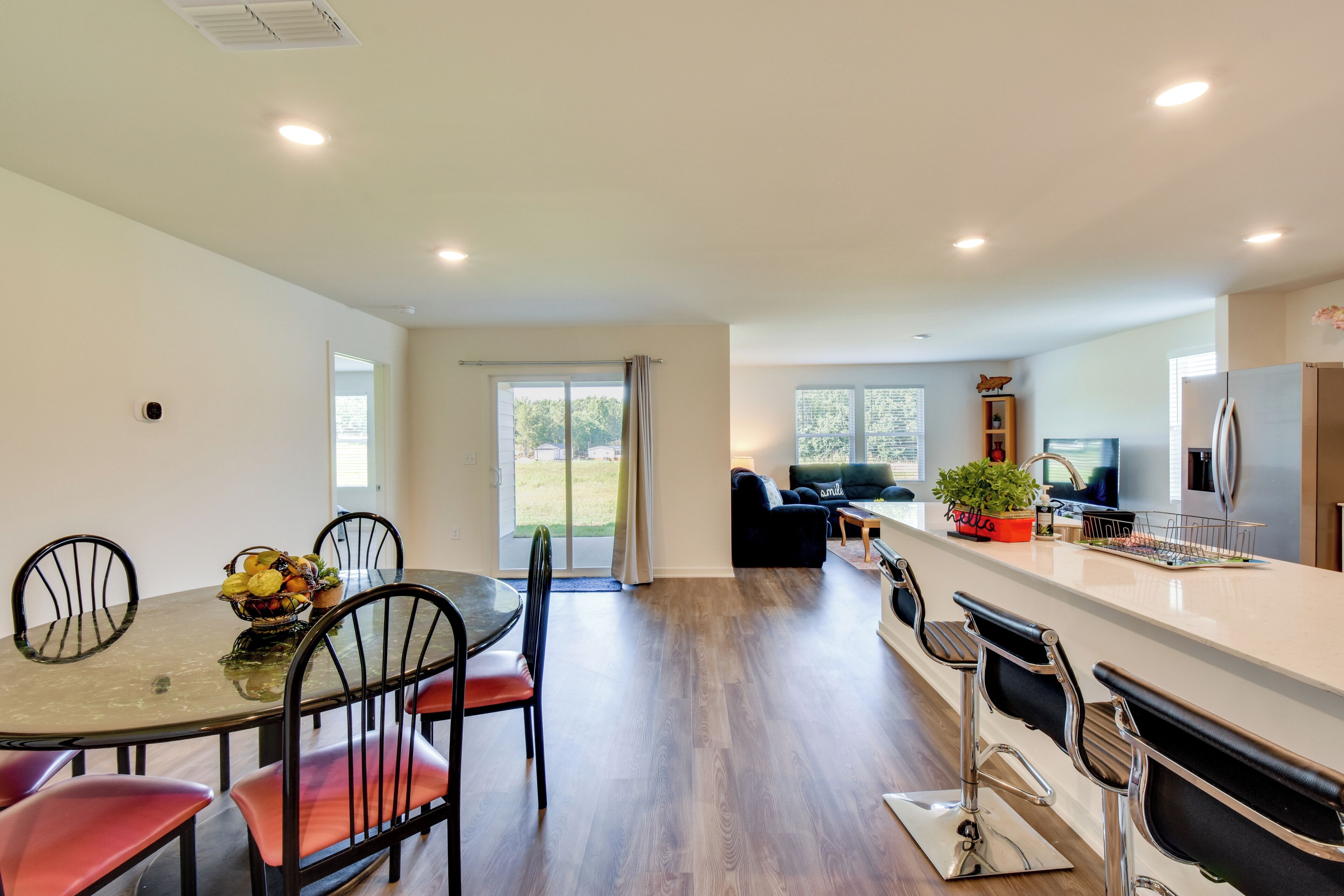 A modern kitchen with a dining area, a large window, and a view of the outdoors.