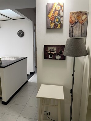 A kitchen with a white countertop, a clock, and wall-mounted artwork. - Center in the city of Genoa (Genova)