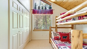 A bunk bed with a forest view, a window with blinds, and a door with a white frame. - Deck, Fire Pit, Hot Tub! Pinetop Family Cabin (Pinetop)