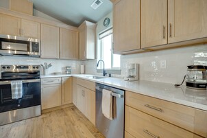 Una cocina moderna con electrodomésticos de acero inoxidable, armarios de madera y lavavajillas integrado.