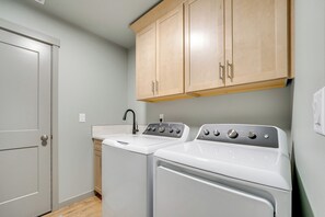 A laundry room with a washing machine, dryer, and a sink.