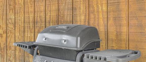 A black grill with a Thermos brand logo, control knobs, and a side handle.