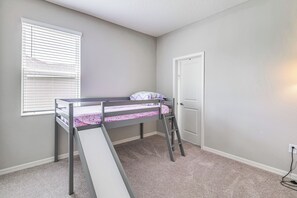 A bedroom with a bunk bed, a window with blinds, a door, and a carpeted floor. - Home Office! Mascotte Family Escape Near Hospital (Mascotte)