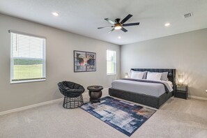 A bedroom with a bed, a chair, a rug, and a ceiling fan. - Home Office! Mascotte Family Escape Near Hospital (Mascotte)