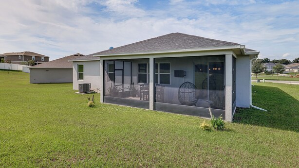 A small, single-story building with a flat roof, large windows, and a grassy lawn. - Home Office! Mascotte Family Escape Near Hospital (Mascotte)