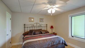 A bedroom with a bed, a ceiling fan, a window with blinds, and a nightstand with a lamp. - Cast & Relax! Lake Greenwood Stay w/ Dock Access (Chappells)