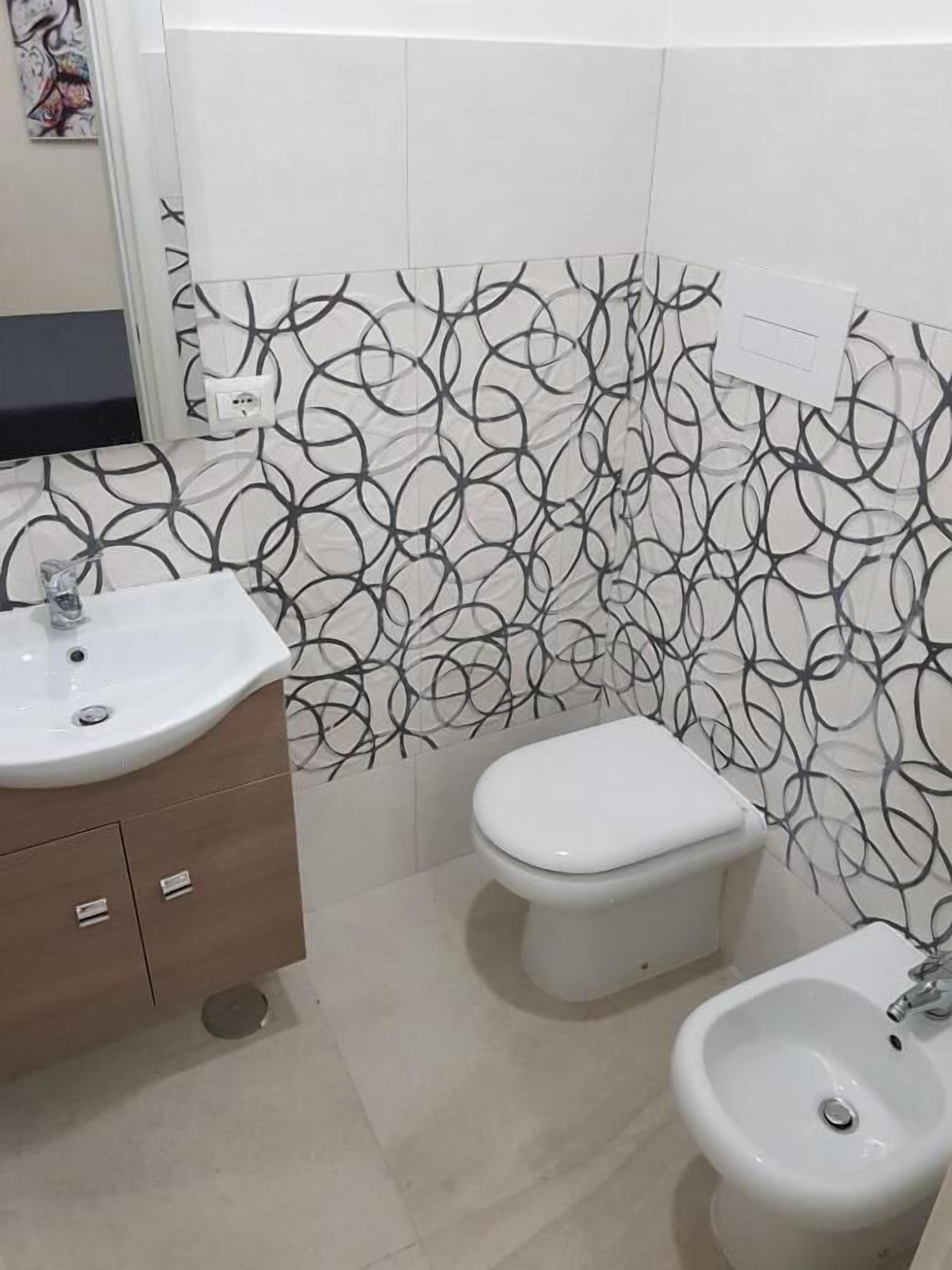 A bathroom with a toilet, bidet, and sink.