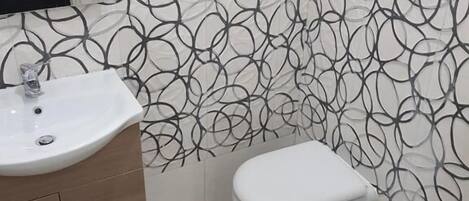 A bathroom with a toilet, bidet, and sink.