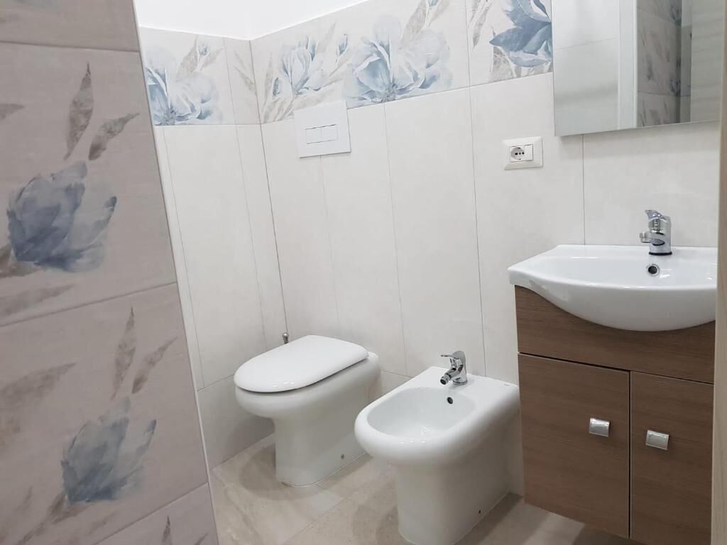 A bathroom with a toilet, bidet, and sink.