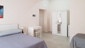 Een slaapkamer met een bed, een bureau en een kledingkast.