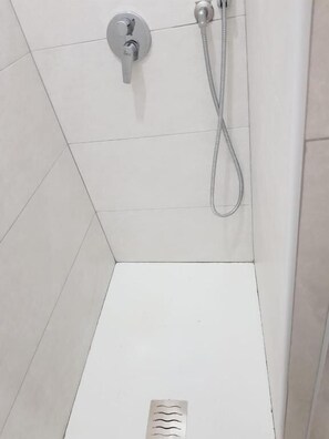 A shower area with a handheld showerhead and a wall-mounted faucet. - B&B La Sapienza (Naples)