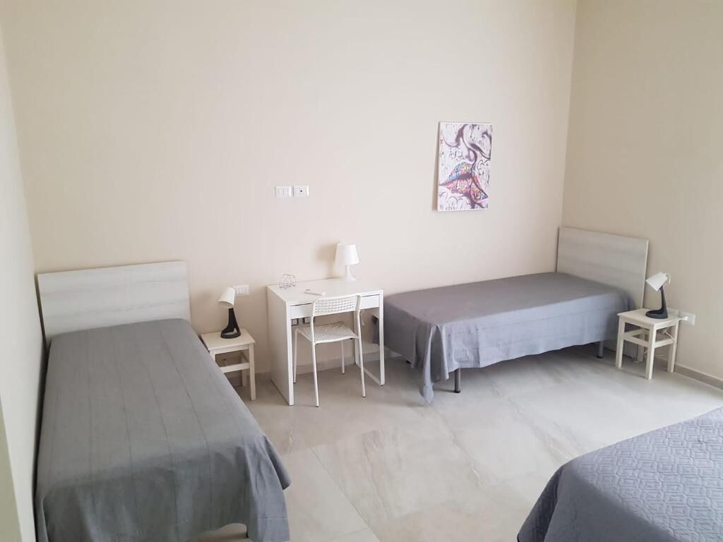 Un dormitorio con dos camas, un escritorio y una silla.